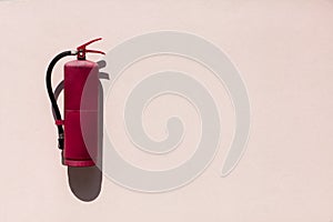 Red old Fire extinguisher hung on concrete wall background.