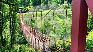 Red old metal structure with wooden pathway bridge in nature in Georgia countryside. Adjara hidden gems