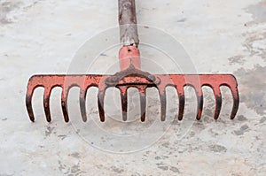 the red old rake on the cement floor ground