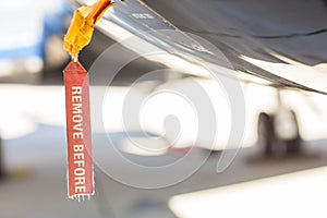 Red old seedy Remove Before Flight Tag on an airplane fuselage