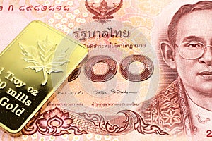 A red one hundred Thai baht note with a gold bar in macro