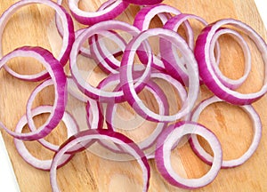 Red onion rings on wooden background