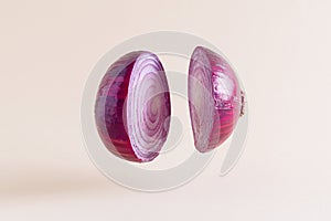 Red onion sliced on pastel earthy colored background. Minimal culinary vegetarian concept. photo