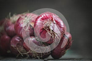 Red onion on a very old oak wooden board. Autumn background. Selective focus.