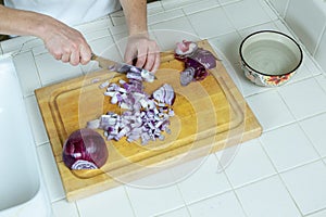 Red onions being sliced and diced on cutting board with a wide-angle view overhead
