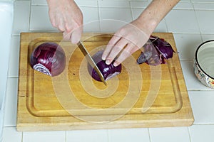 Red Onions being sliced on kitchen cutting board