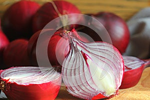 Red onions on wooden chopping cutting board over dark wooden rustic texture background. Top view, space for text