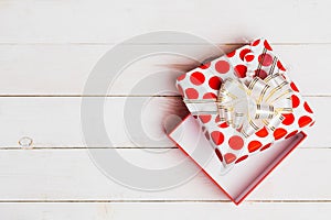 Red open gift box with ribbon on white background on white wooden background with copy space, top view. Christmas, birthday, new