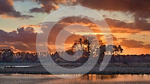 Red and orange colored sunset reflected in water at a wetland, Turnhout, Belgium