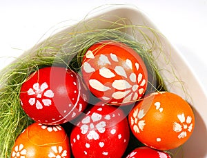 Red and orange easter eggs in a white plate