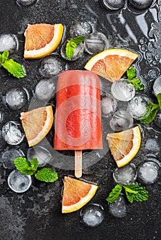 Red orange juice homemade popsicle over ice