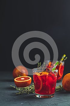 Red orange juice in a large glass or blood orange sparkling vodka cocktail or aperitif with campari