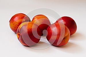 red-orange nectarines lie on a white background. Healthy and healthy food, organic fruit closeup