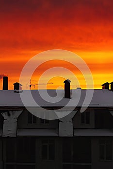 Red, orange, vivid sky at sunrise over the building in the city.