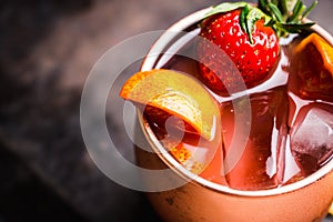 Red oranges and strawberry cocktail in copper mug variation of Moscow mule on the wooden background