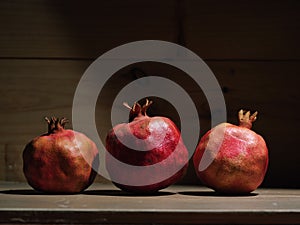 Red organic grown pomegranates in bright sunlight with copyspace. Natural fruit concept image photo