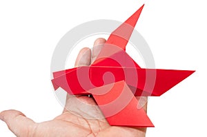 Red origami bird sitting on the hand