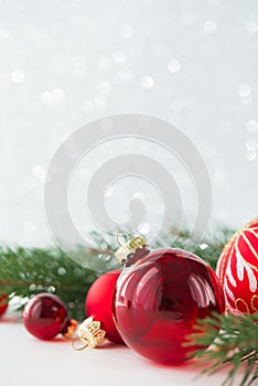 Red ornaments and xmas tree on glitter holiday background. Merry christmas card.