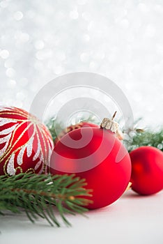 Red ornaments and xmas tree on glitter holiday background. Merry christmas card.