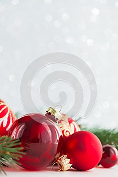 Red ornaments and xmas tree on glitter holiday background. Merry christmas card.