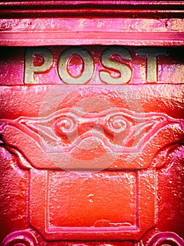 Red ornate mailbox detail with the word post on it