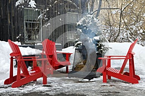 Red Outdoor Chairs with Smoking Fire Pit during Winter