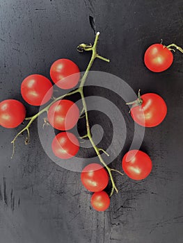 Red pachino tomatoes grape on a bÃ²ack wooden background