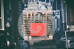 Red padlock on computer motherboard cooling cpu chip. Internet data privacy information security concept. Toned image.