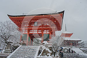 Red Pagoda at Kiyomizu-dera temple with tree covered white snow background.