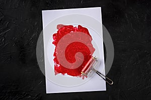 Red paint background with a roller, an abstract texture
