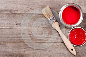 Red paint in the bank to repair and brush on the old wooden background with copy space for your text. Top view