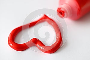 Red paint squeezed out of tube in shape of heart closeup