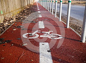 Red painted bicycle lane with small aluminium pilons