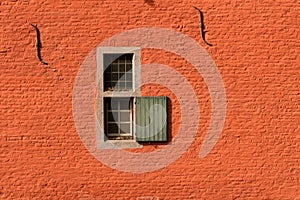 Two small windows in a red brick wall