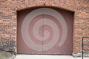 Red painted wood double door entrance of the brick structure