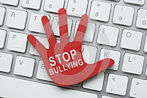 Red palm on the keyboard with the inscription stop bullying. Cyberbullying concept.