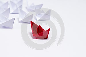 A Red paper boat with white boats following it in Leadership concept
