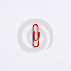 Red paper clip on white background with copy space