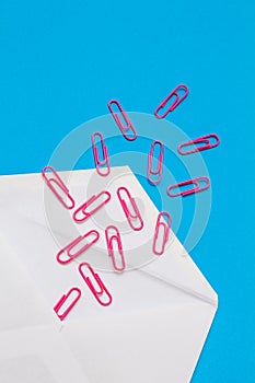 Red paper clips coming out from envelope
