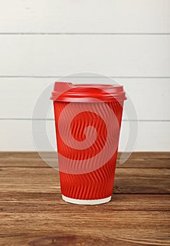 Red paper coffee cup over white wall