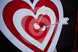 Red paper heart in the center of darts target