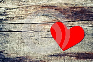 Red paper heart on grunge wooden background