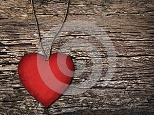 Red paper heart on a string on the wooden background