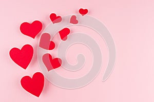 Red paper hearts soar on pink color background, copy space. Valentines day backdrop.