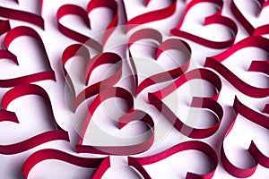 Red paper hearts on the white paper background. Valentine background concept full of paper hearts.