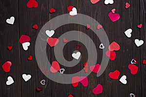 Red paper hearts on wooden background.