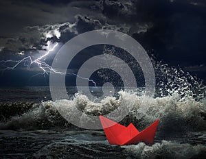 Red paper ship in storm concept