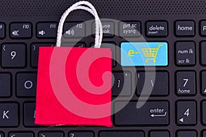 Red paper shopping bag on laptop keyboard. Ideas about online sh