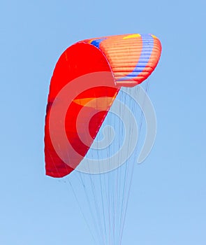 Red parachute against a blue sky