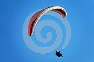 Red paraglider in a blue sky